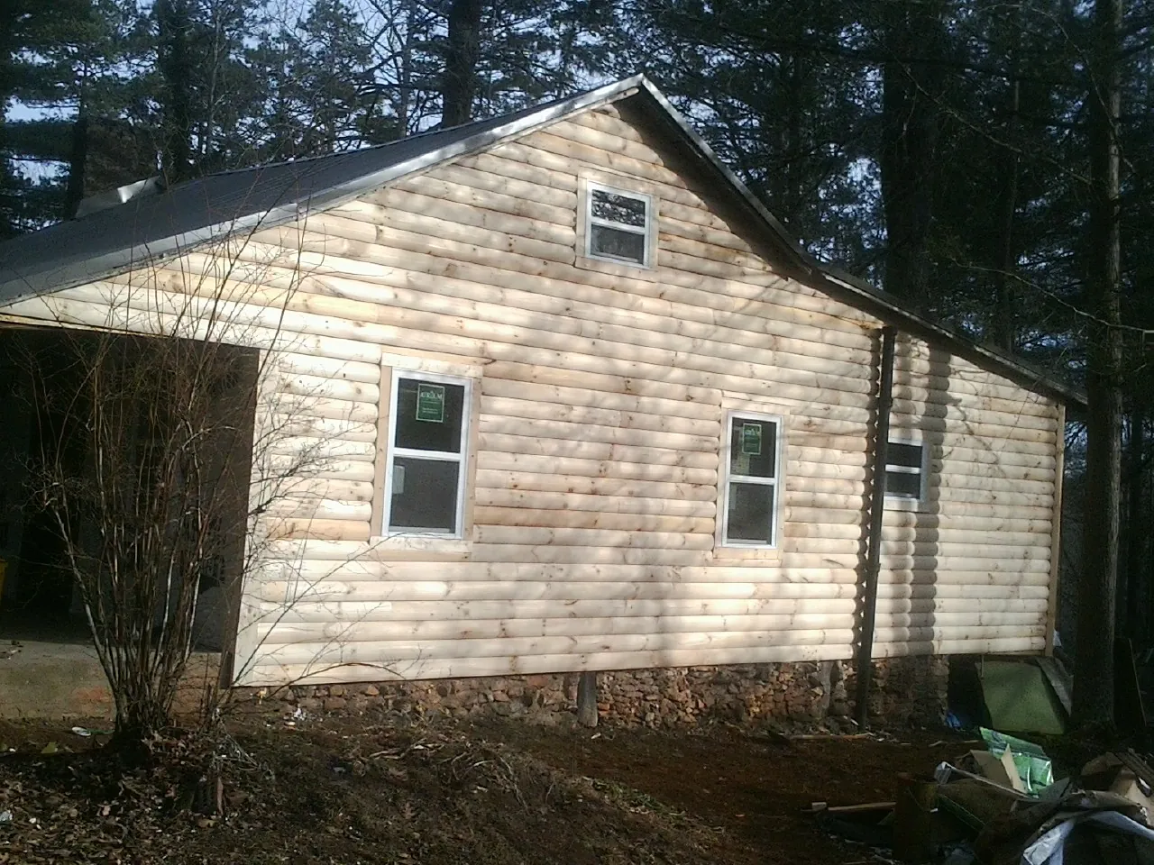 New log siding and dark metal roofing on a gable end in Cusseta