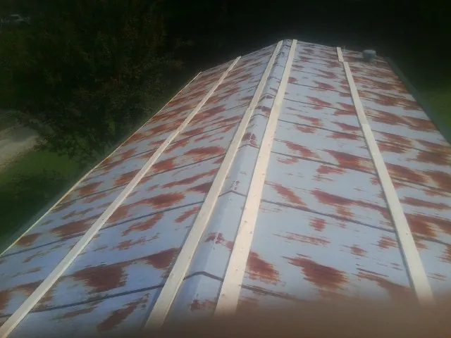 Rusted metal roof panels with new wood purlins before replacement — Storm Damage Roof Repair in Cusseta by Roofing Brothers