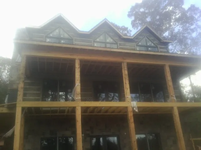 Dormers and porch framing on a large log home under construction — Roof Coating work by our crew in Cusseta