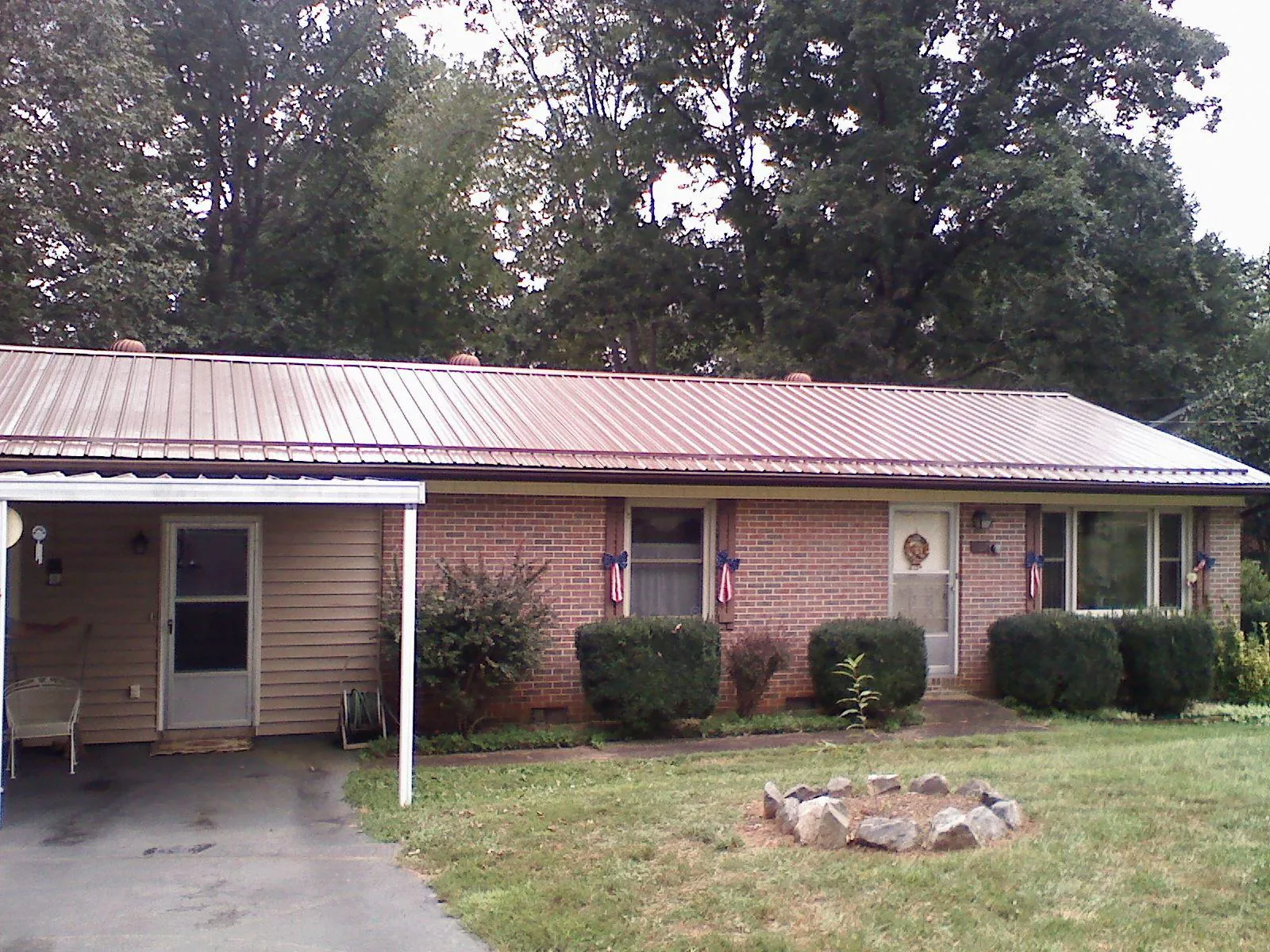 Bronze metal roof and carport on a brick ranch home — Roof Repair work by our crew in Cusseta